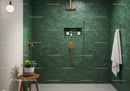 Modern green tiled shower with gold fixtures and plant