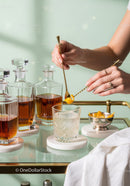 Elegant Cocktail Preparation with Gold Tools and Crystal Glasses