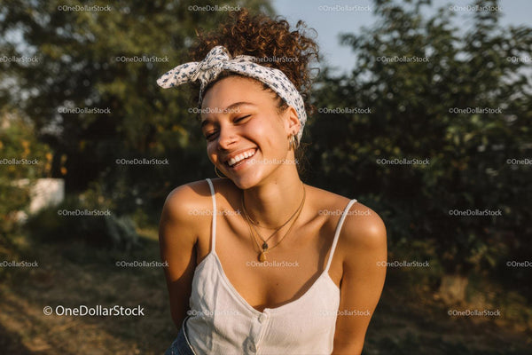 Joyful Young Woman Smiling in Summer Outdoors with Headscarf