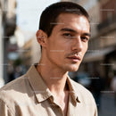Thoughtful young man in casual beige shirt outdoors