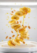 Sliced banana with honey drizzle and peanuts falling
