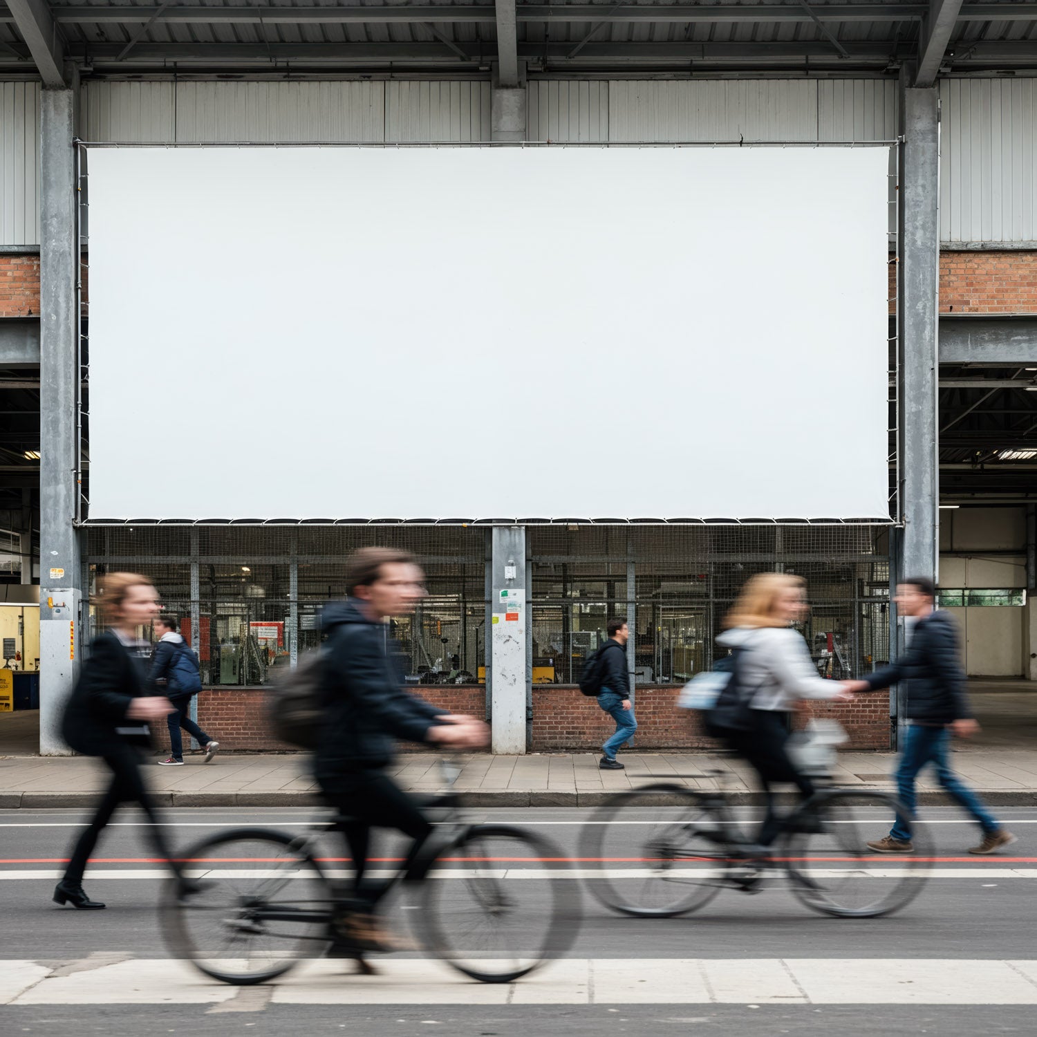 Rozmazane sylwetki dojeżdżających do pracy rowerzystów i pieszych obok pustego billboardu