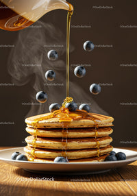 Stack of warm pancakes with honey and fresh blueberries
