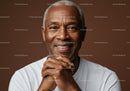 Senior Man with Hands Together Over Warm Brown Background