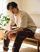 Thoughtful young man sitting on wooden bench indoors
