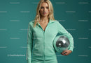 Young Woman in Mint Green Tracksuit Holding Disco Ball in Studio