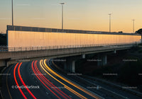 City Traffic Lights and Highway Overpass at Sunset with Motion Light Trails