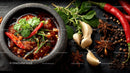 Spicy Asian Beef Stew with Rice and Fresh Herbs in a Black Stone Bowl