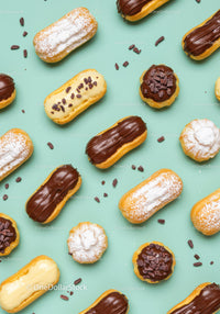 Assorted éclairs and cream puffs on mint background