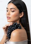 Elegant Woman with Flawless Skin Holding Grapes in Soft Light