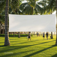 Blank banner hanging between palm trees on green lawn
