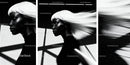 Stylish woman with flowing white hair in urban shadow