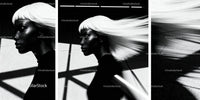 Stylish woman with flowing white hair in urban shadow