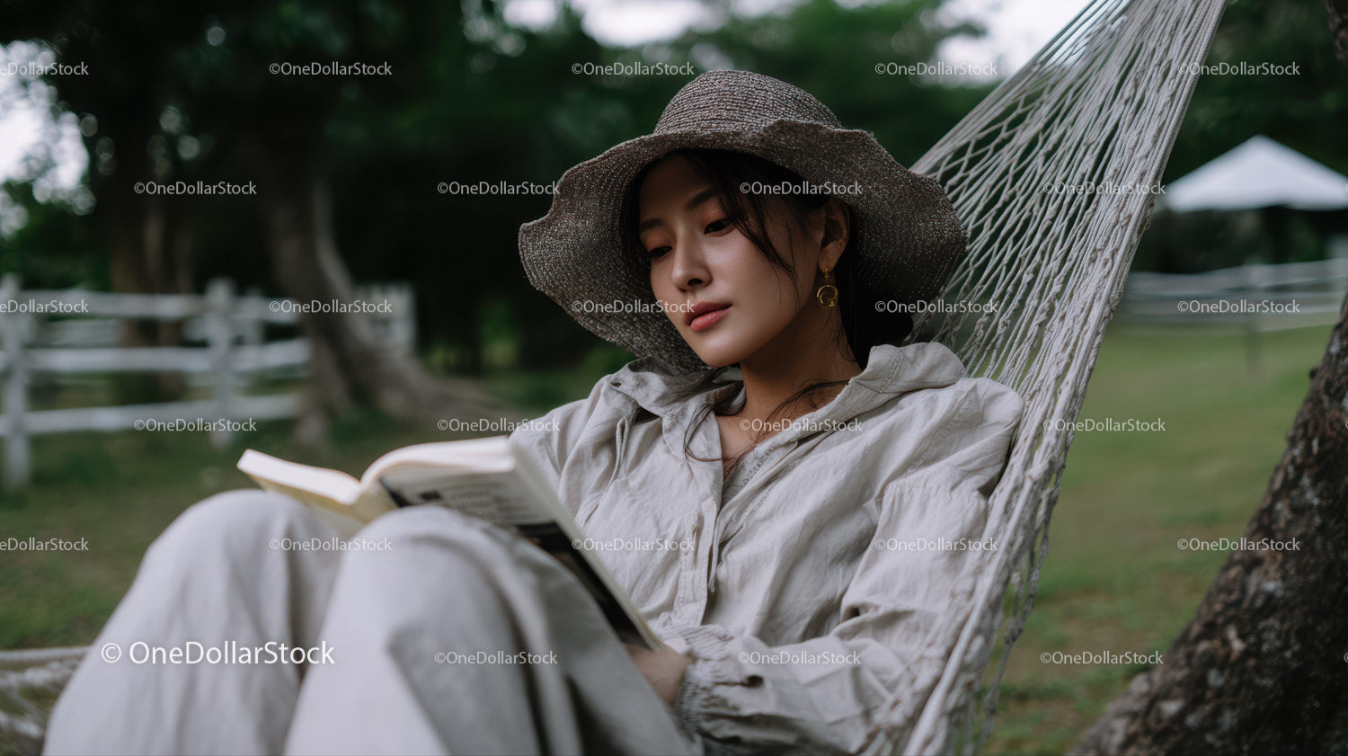 Relaxing Woman Reading Book in Hammock Outdoors in Nature