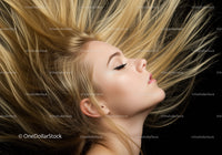 Profile of young woman with flowing blonde hair on black