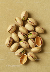 Close up of roasted pistachios in shells on textured background