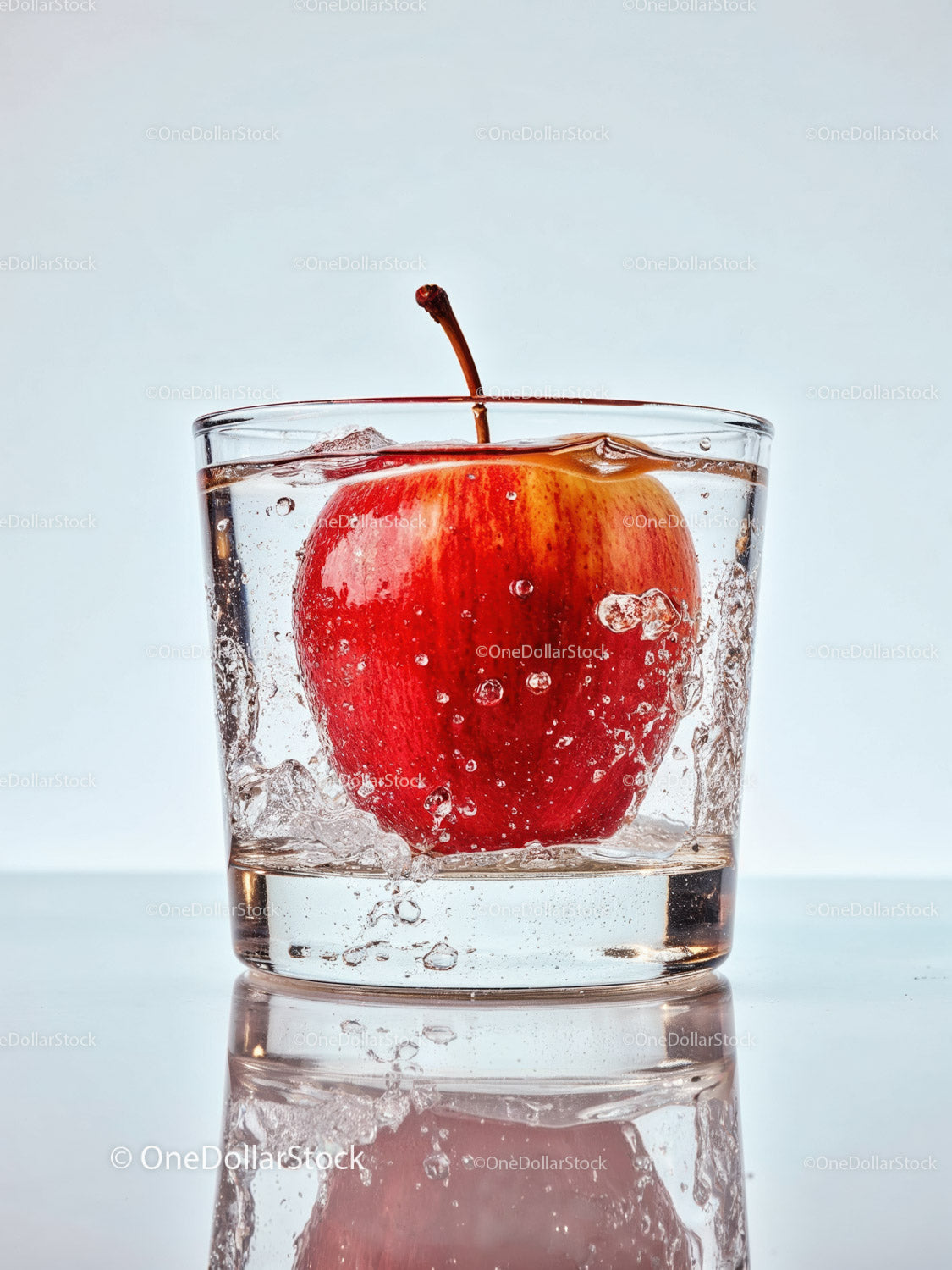 Fresh Red Apple Immersed in Clear Water Glass