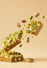 Crunchy pistachio nut bar breaking apart midair