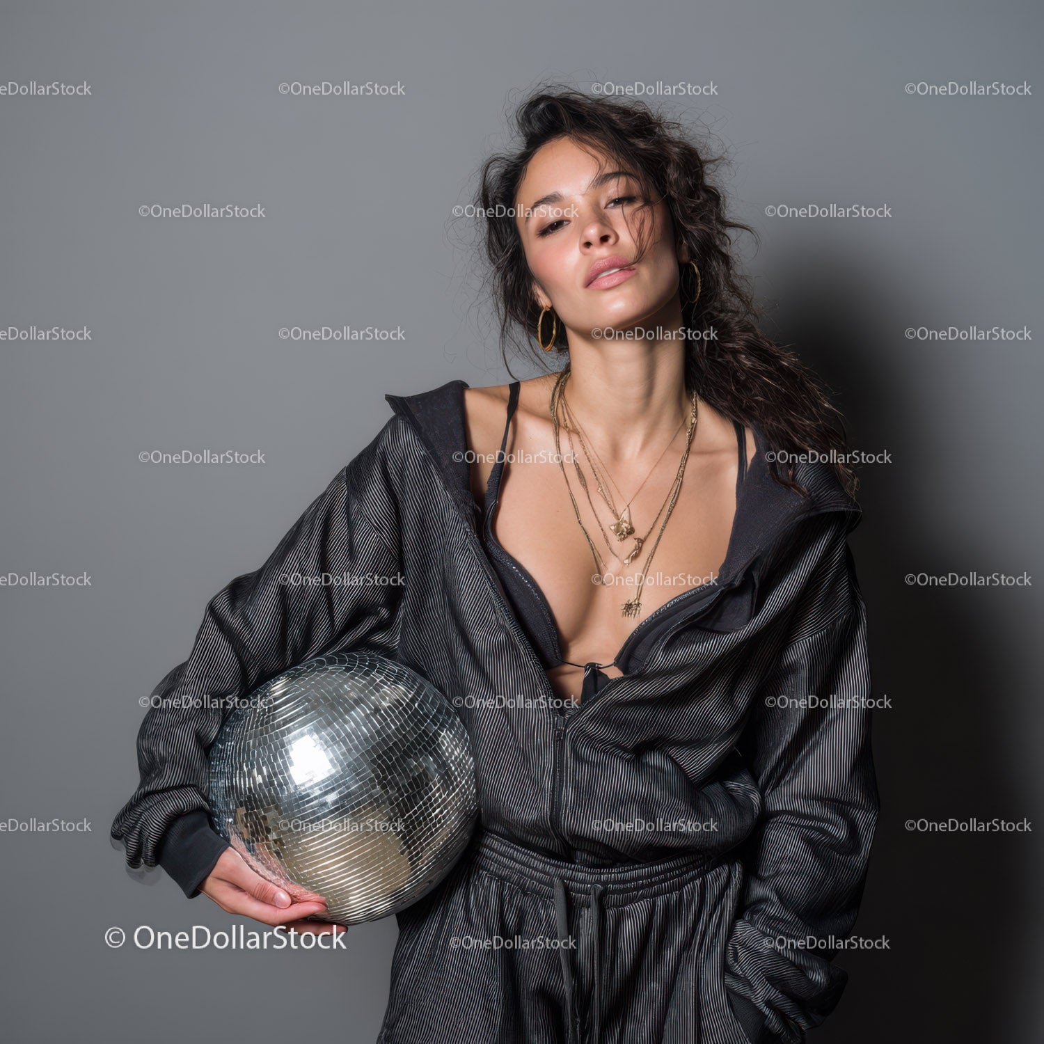 Stylish Woman in Metallic Outfit Holding Disco Ball for Modern Fashion