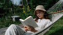 Woman Relaxing and Reading in Hammock in Green Garden Scene