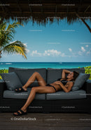 Relaxing Woman on Outdoor Sofa by Tropical Beach During Sunlit Day