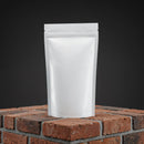 Minimalist White Stand-Up Pouch on Brick Surface
