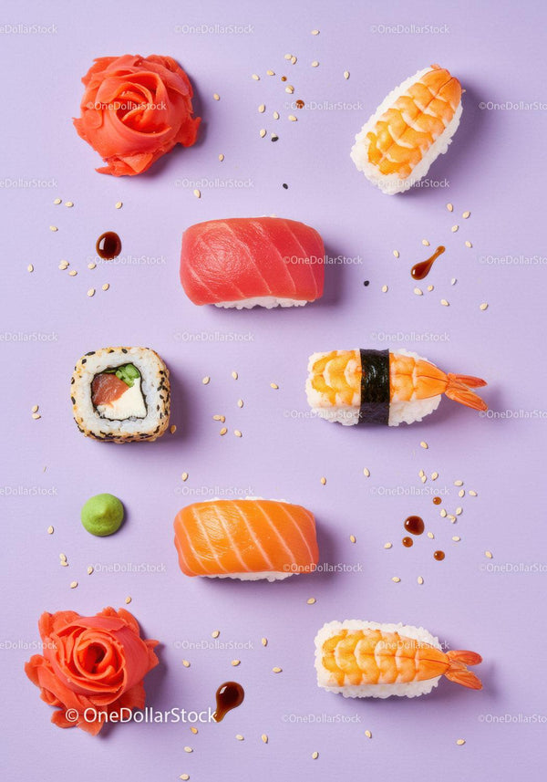 Assorted sushi pieces with garnishes on pastel background