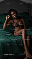 Smiling woman relaxing on bed in black lace lingerie