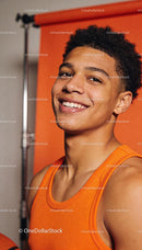 Confident young athlete smiling in bright orange top