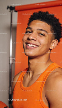 Confident young athlete smiling in bright orange top