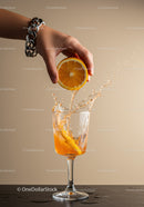 Hand Squeezing Fresh Orange Juice Into Glass