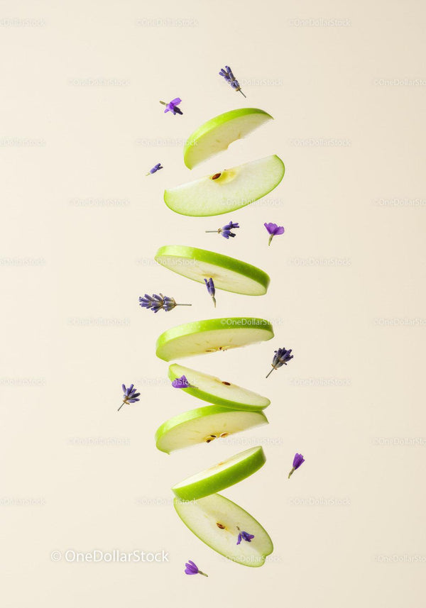 Floating green apple slices with purple flowers