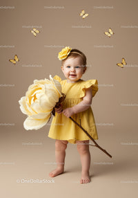 Toddler in Yellow Dress Holding Giant Flower with Butterflies