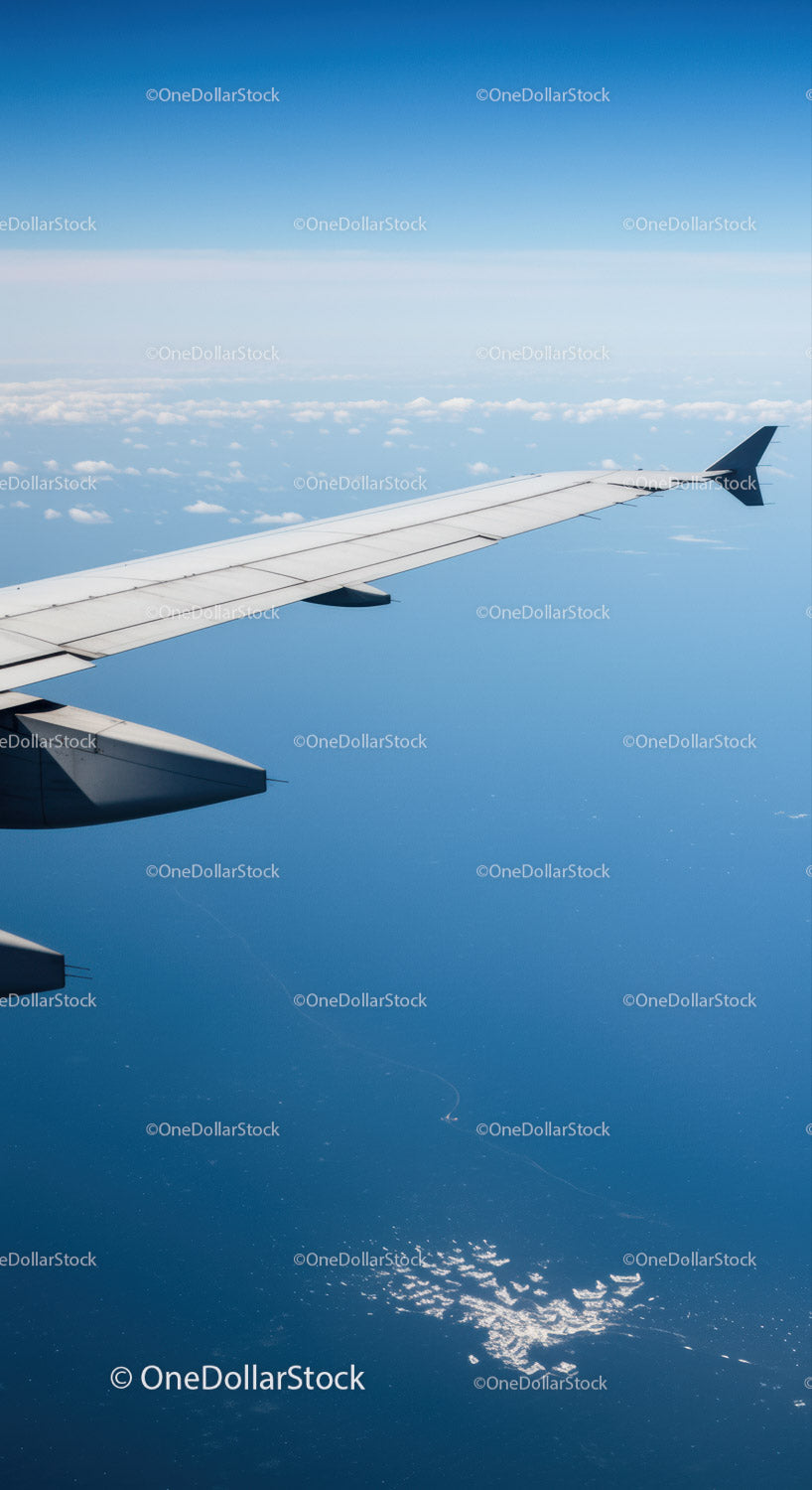 Aerial View of Airplane Wing Over Clouds in Clear Blue Sky