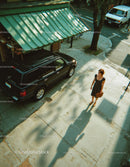 Woman Walking on City Sidewalk with Briefcase in Urban Scene