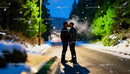 Couple Sharing a Kiss on Snowy Winter Road at Twilight