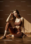 Young woman relaxing in sunlight in brown athleisure