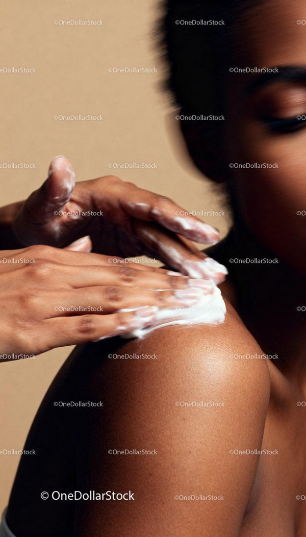 Close up of woman applying moisturizer cream on shoulder