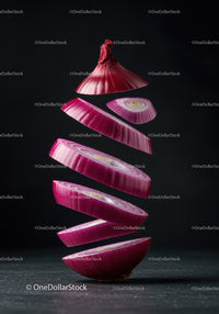 Floating slices of fresh red onion on dark background