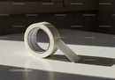 Roll of white adhesive tape on smooth surface