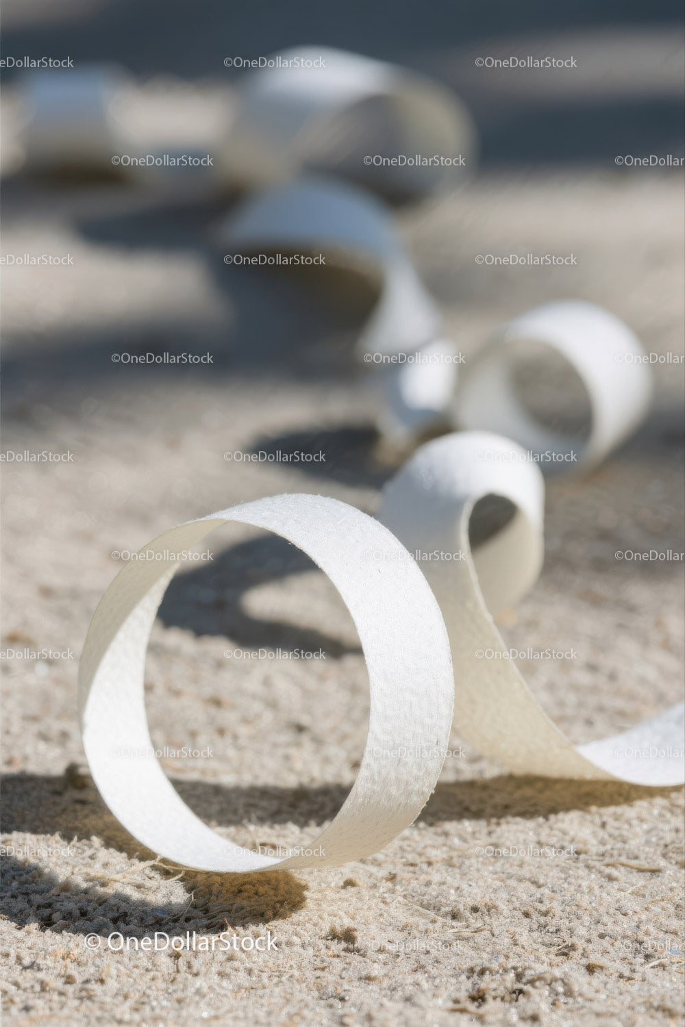 Close-up of White Plastic Ribbon Waste on Sandy Beach
