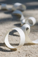 Close-up of White Plastic Ribbon Waste on Sandy Beach