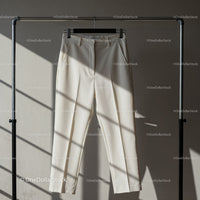 Elegant beige trousers hanging on metal rack
