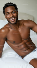 Smiling man relaxing on bed in white underwear