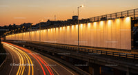 Cityscape of a Highway at Sunset with Light Trails and Urban Skyline