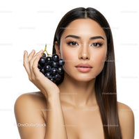 Young Woman with Black Hair Holding Fresh Black Grapes in a Portrait