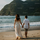 Woman and Child Walking Hand in Hand Along the Sunny Beach Coast