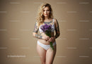 Young Woman with Tattoos Holding Purple Flowers In Studio