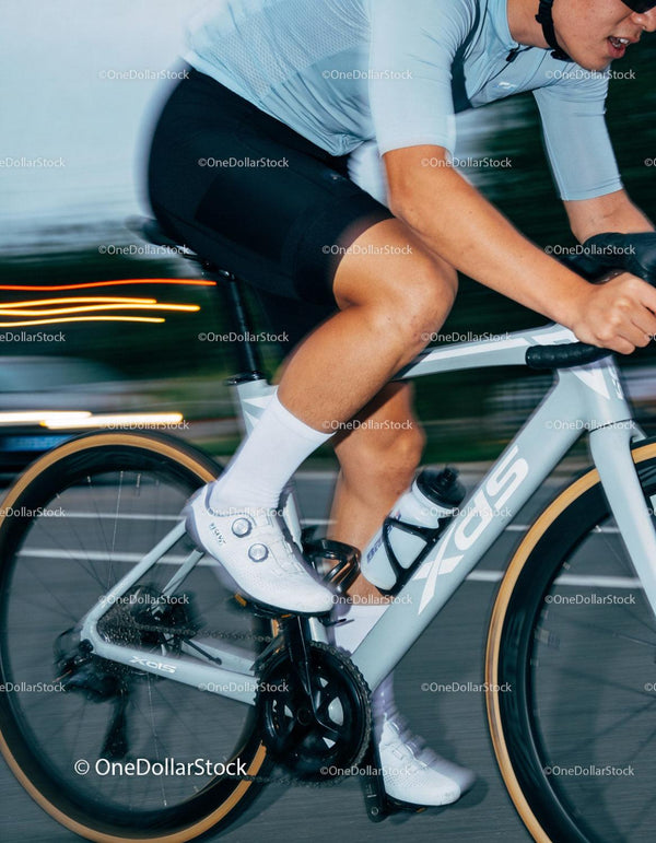 Close-up of cyclist pedaling fast on city road