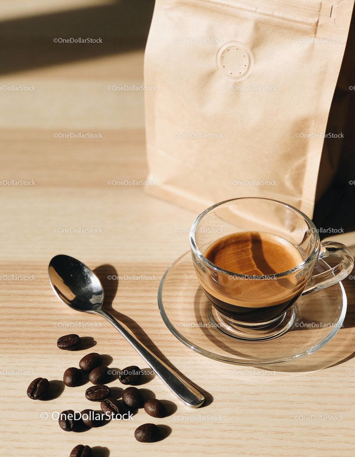 Freshly brewed espresso with coffee beans and spoon